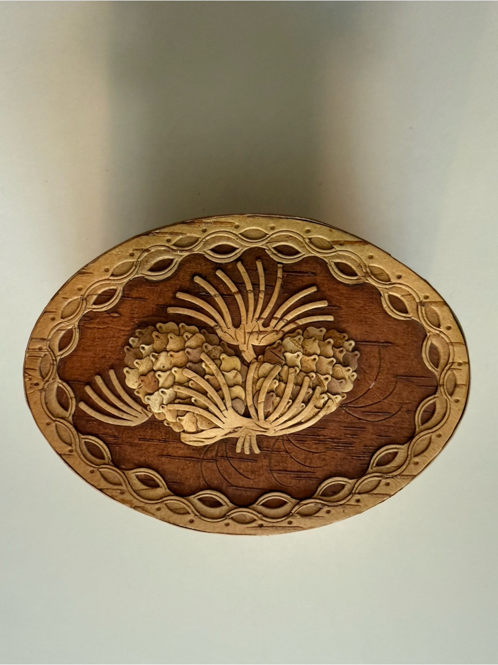 Oval Russian birch bark trinket box featuring an intricately carved pinecone lid